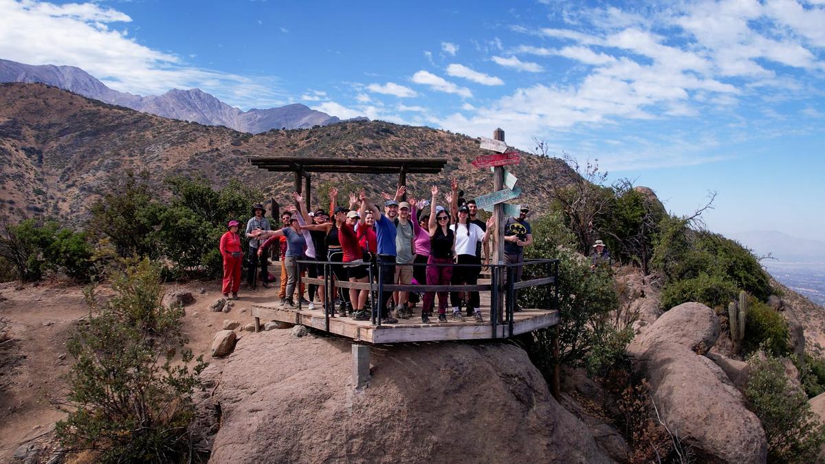 Colaboradores de FEMSA Salud celebrando en un mirador de montaña durante un trekking