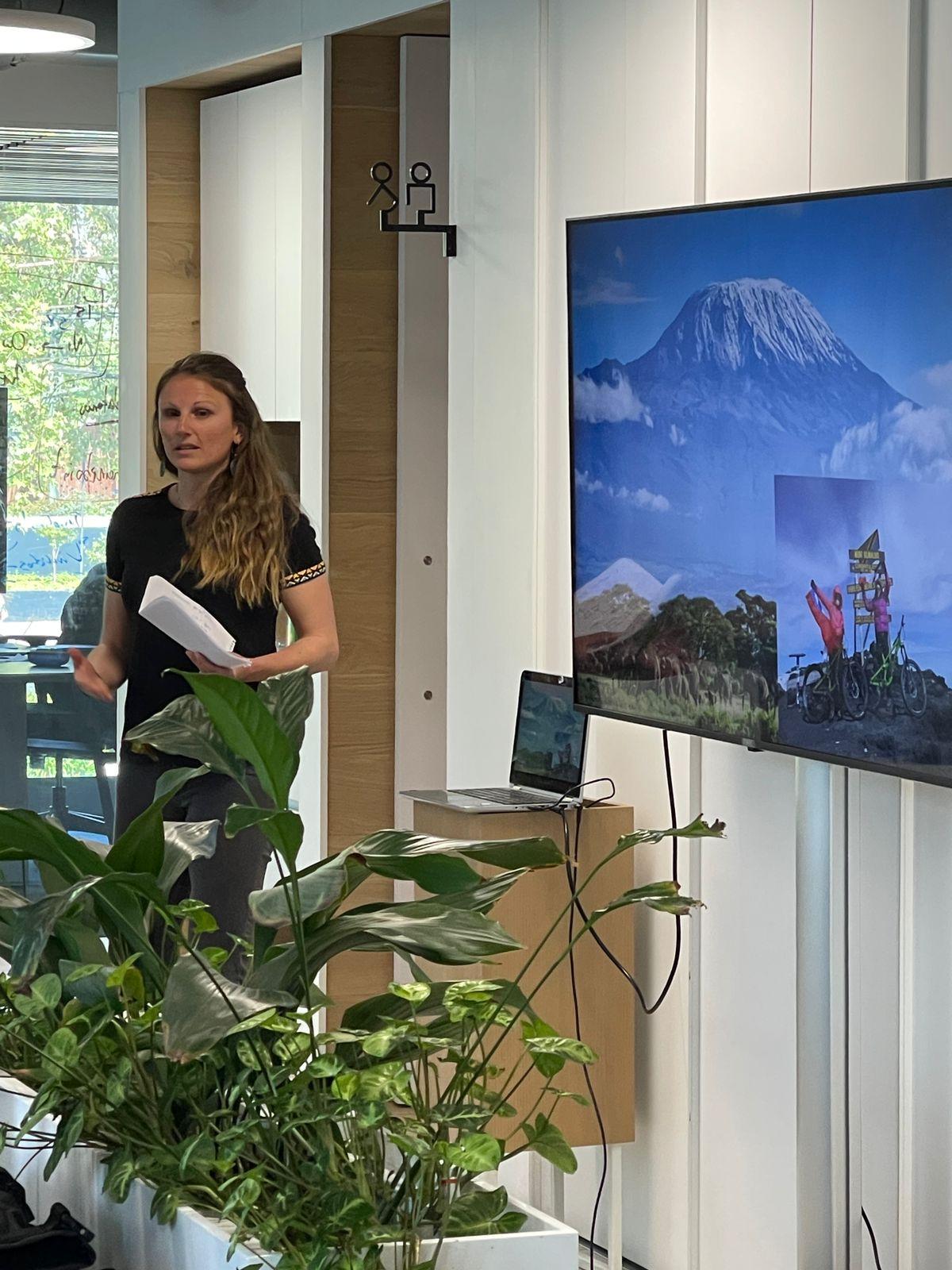 Helene Manche dictando una charla en una oficina, junto a una pantalla con el Kilimanjaro