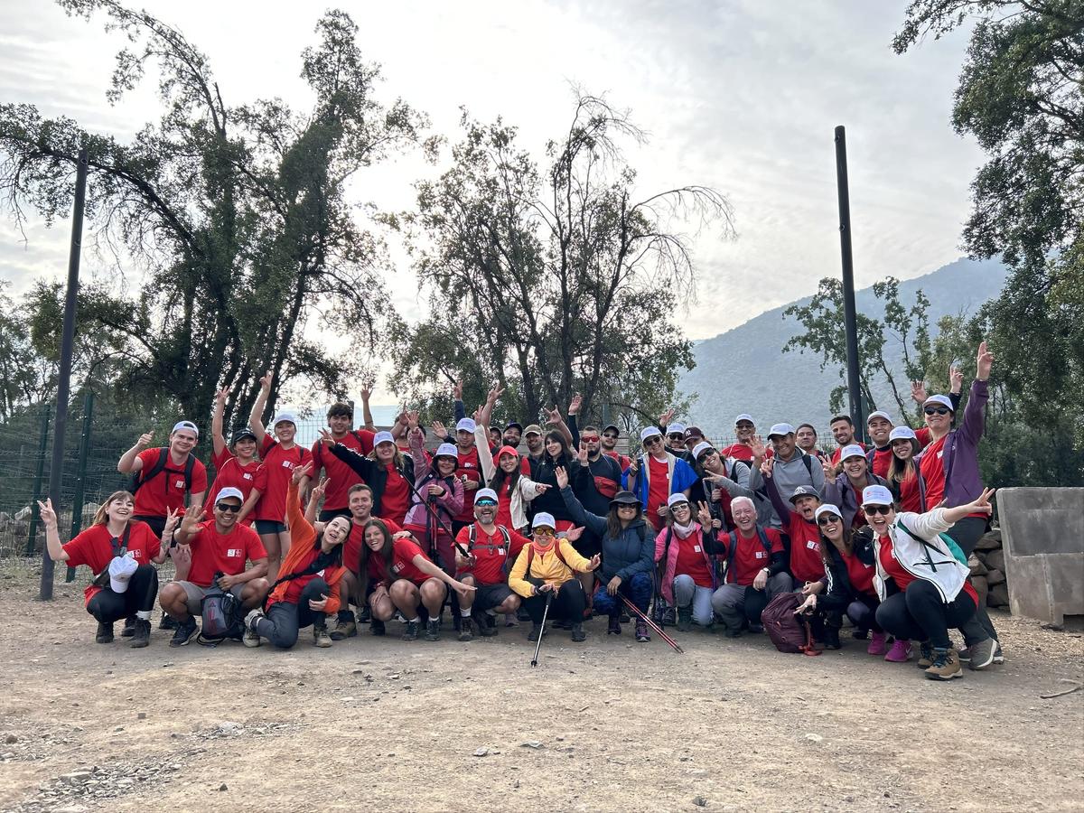 Equipo celebrando en salida grupal frente a la cordillera