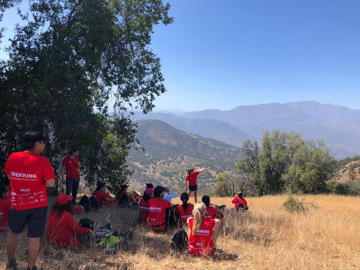 Grupo en trekking escuchando a la guía con la cordillera de fondo