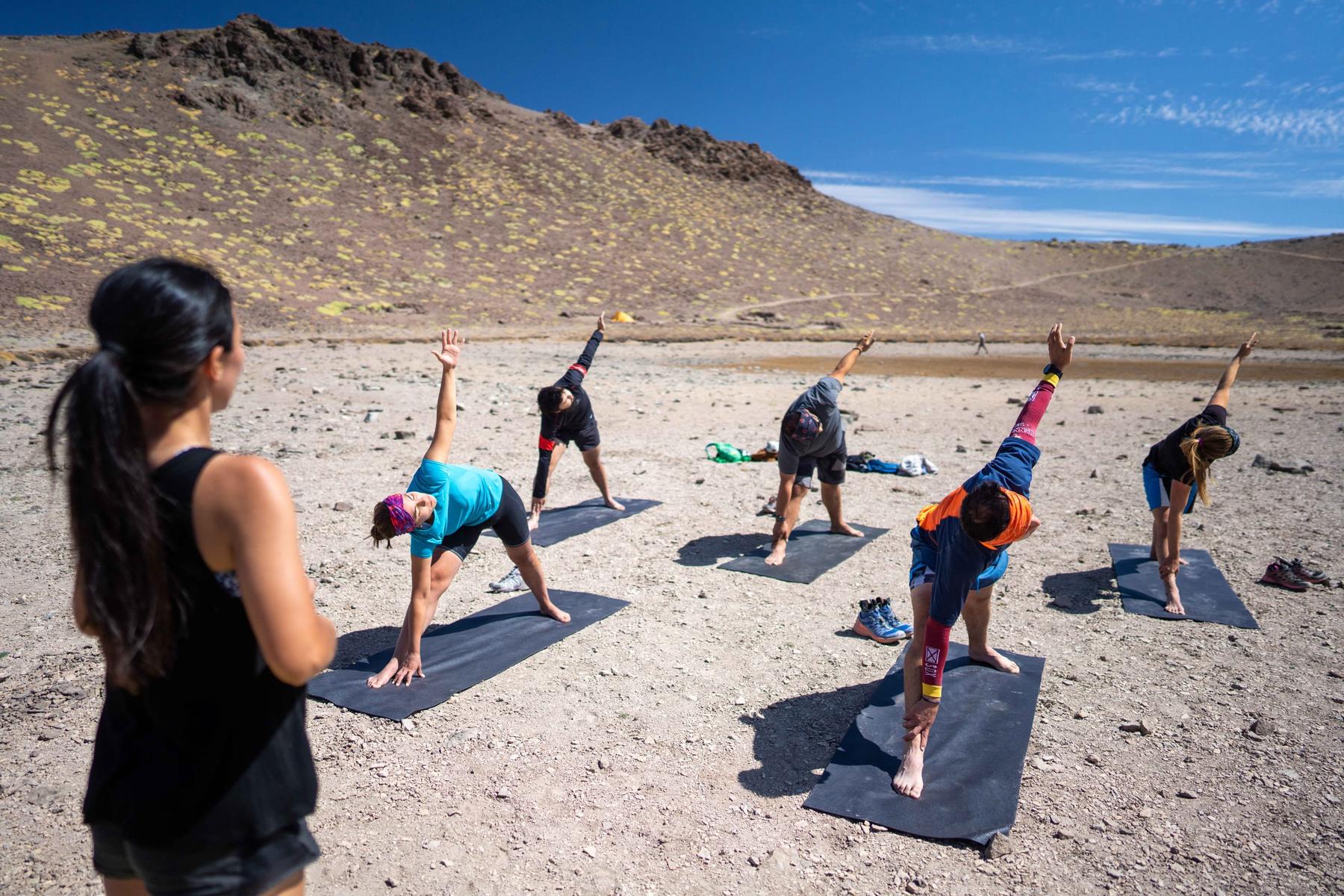 Grupo haciendo yoga al aire libre en la cordillera